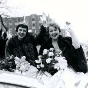 The women of the Saint Louis University Homecoming Court ride in a car and wave during the Homecoming Parade. (1955)